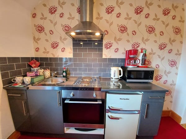 Kitchenette in Axminster B&B Suite, with oven, hot plates, and refrigerator